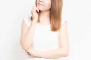 悩むジェスチャーをする女性